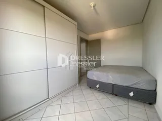 Quarto com cama e paredes brancas em um imóvel.