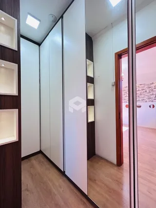 Hall de entrada com piso de madeira e armários embutidos.