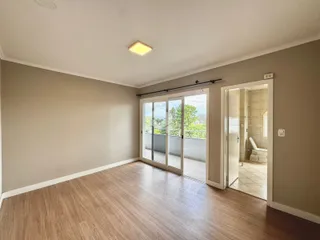 Ambiente interno de uma sala com piso de madeira clara.