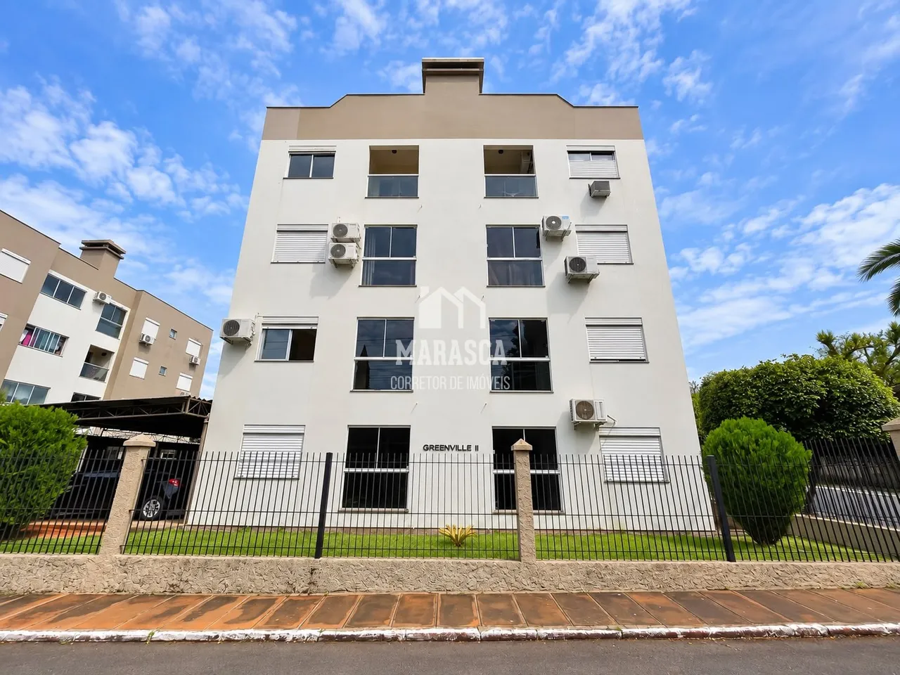 Fachada de um prédio residencial em Lajeado, Brasil, com cerca de metal.