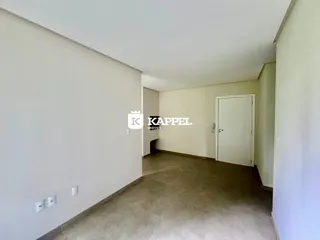Hall de entrada com paredes brancas e piso claro.