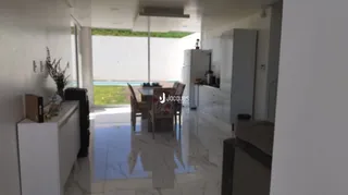 Um corredor interno com piso de cerâmica e paredes brancas é visível na propriedade.