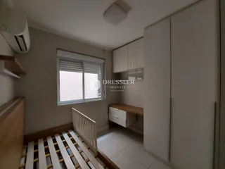 Quarto com cama de madeira e armários em um ambiente claro.