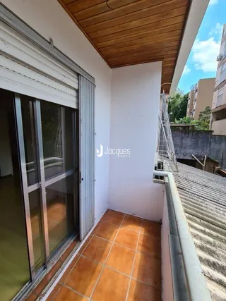 Vista de um corredor interno com piso de cerâmica e teto de madeira.