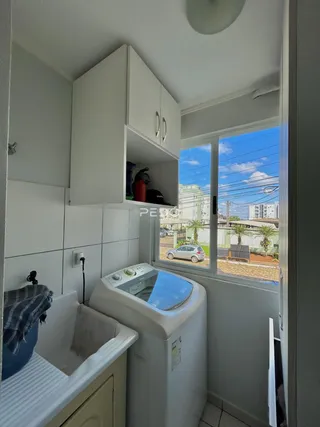 Foto de um banheiro com máquina de lavar e janela.