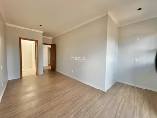 Hall de entrada com piso de madeira clara.
