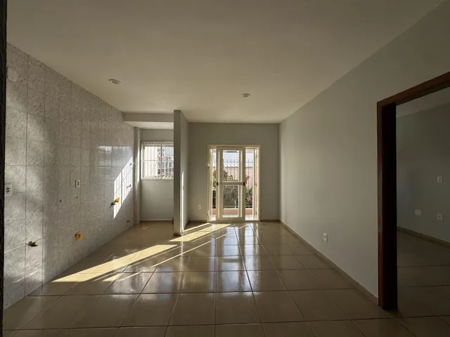 Hall de entrada com piso de cerâmica e paredes brancas.