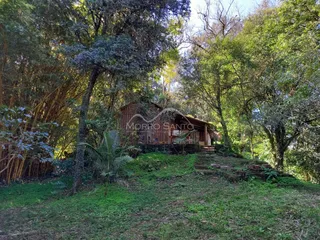 Vista externa de uma casa rústica em Lajeado, Brasil, cercada por vegetação densa.