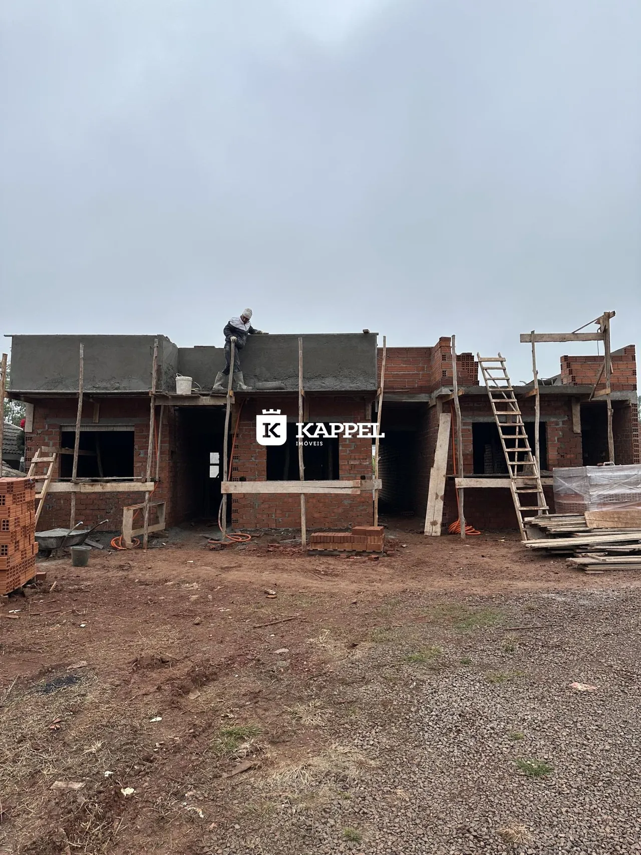 Uma construção residencial em estágio de obra é visível no terreno.
