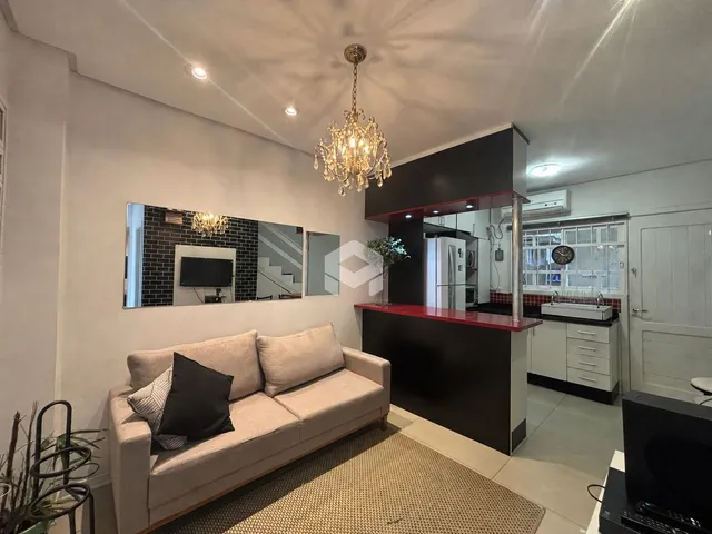 Sala de estar com sofá e área de cozinha moderna em um imóvel no Brasil.