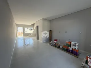 Interior de um espaço vazio com paredes brancas e piso claro.