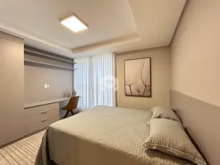 Quarto com cama e armário em um ambiente claro.