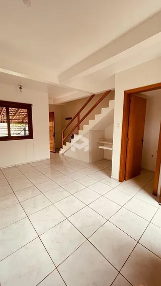 Vista interna de um ambiente com piso de cerâmica e escadaria.