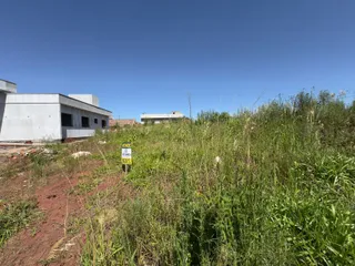 Vista externa de uma construção em Lajeado, Brasil, com vegetação alta no primeiro plano.