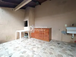Interior de uma sala com piso de cerâmica e móveis de madeira.