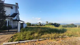 Vista da fachada de uma casa em Lajeado, Brasil, com área de grama alta na frente.