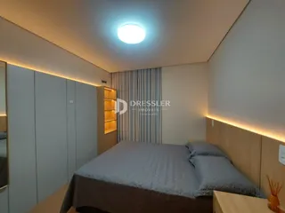 Quarto com armários embutidos e cabeceira de madeira.