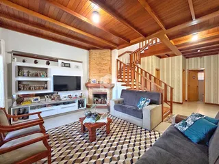 Sala de estar com pé direito alto e lareira em madeira.
