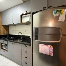 Cozinha moderna com armários cinzas e bancadas escuras.