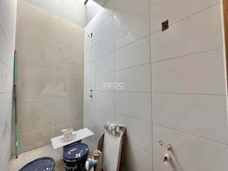 Parede interna com revestimento cerâmico e acabamento em obra.