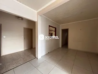Hall de entrada com paredes brancas e piso de cerâmica.