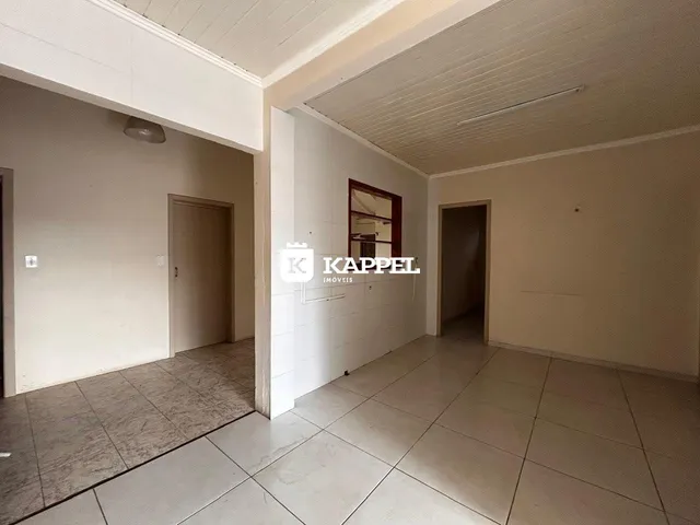 Hall de entrada com paredes brancas e piso de cerâmica.