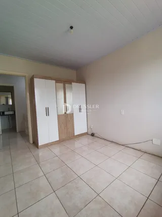 Quarto com armários embutidos e piso de cerâmica clara.