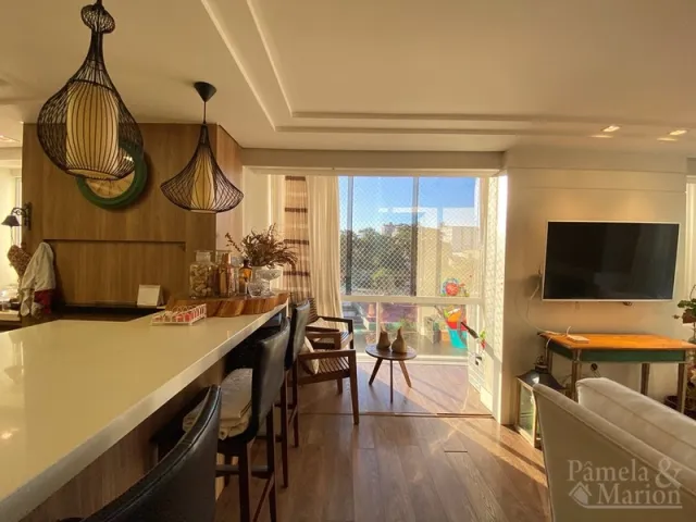 Sala de estar com bancada e janela de vidro em um imóvel.