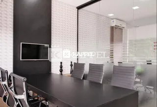 Uma sala com mesa escura e cadeiras em um ambiente moderno.