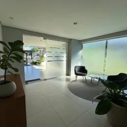Sala de estar com piso claro e porta de vidro.