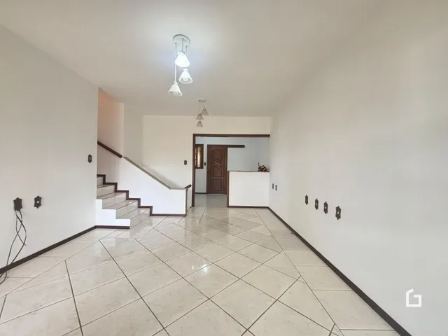 Hall de entrada com piso de cerâmica e escadaria em uma residência.