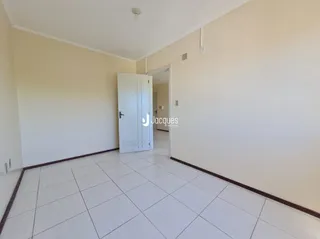 Vista interna de um ambiente com piso de cerâmica e paredes brancas.