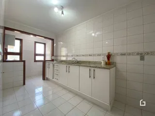 Ambiente interno com revestimento cerâmico branco nas paredes e piso.