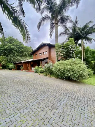 Fachada de uma residência em Lajeado, Brasil, com jardim e área pavimentada.