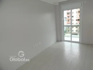 Interior de um cômodo com piso de madeira e grande porta de vidro.