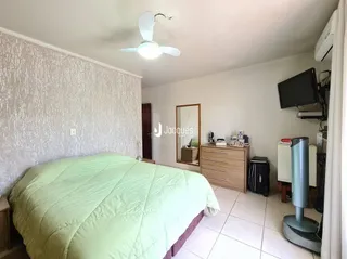 Quarto com cama grande e paredes brancas.