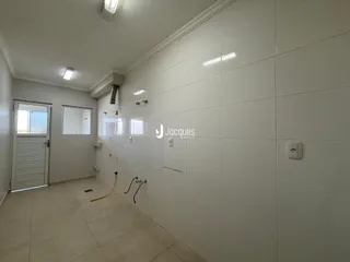 Corredor interno com paredes e piso revestidos de cerâmica.