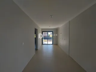 Vista do corredor interno de uma residência com piso claro.