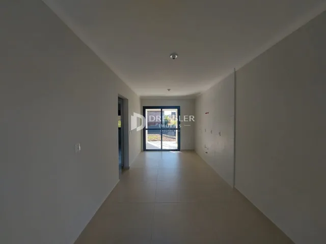 Vista do corredor interno de uma residência com piso claro.