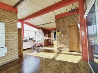 Ambiente interno com paredes de tijolo aparente e piso de madeira.