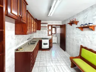 Foto de uma cozinha com armários de madeira e piso cerâmico.