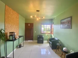 Ambiente interno de uma sala com paredes verdes e piso claro.