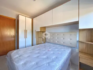 Quarto com cama grande e armários brancos em um imóvel no Brasil.