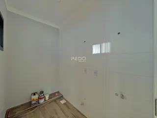 Parede branca com piso de madeira clara em um ambiente interno.