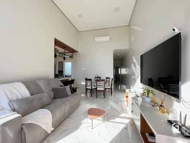 Sala de estar com piso de mármore claro e sofá cinza claro.