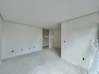 Imagem de um cômodo interno vazio com paredes brancas.
