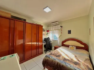 Quarto com armário de madeira e cama no interior de uma residência.