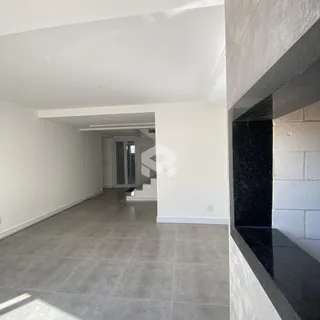 Vista de um corredor interno com piso de cerâmica clara.