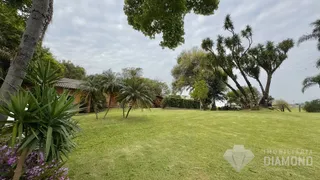 Gramado verde extenso com árvores ao fundo em uma propriedade.