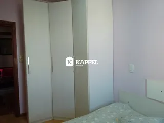 Foto de um quarto com armários brancos e uma cama visível.